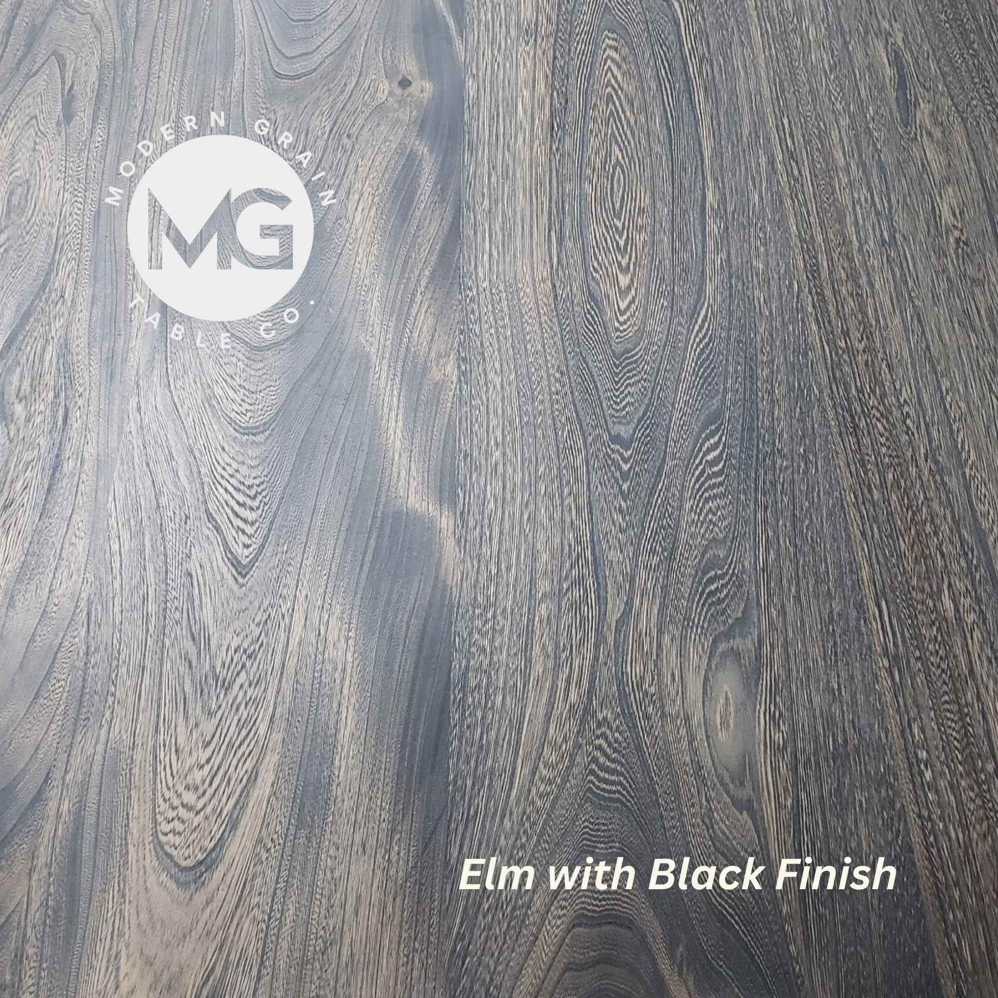 Close-up of Elm hardwood with Black finish from Modern Grain Table Co., featuring striking grain contrast, rich texture, and a bold modern tone.