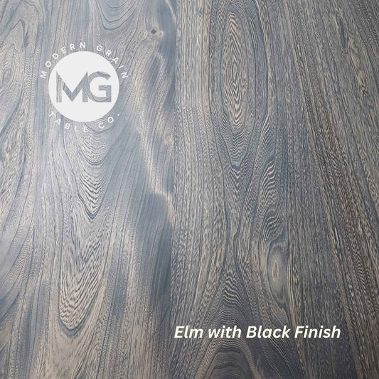 Close-up of Elm hardwood with Black finish from Modern Grain Table Co., featuring striking grain contrast, rich texture, and a bold modern tone.